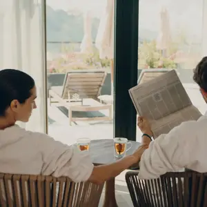 Casal de roupão na suíte do resort.