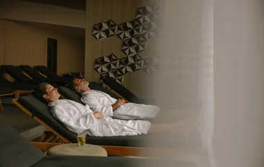 Um homem e uma mulher, de roupão sentados em cadeiras de SPA
