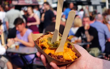 Pessoa segurando um pote de poutine.