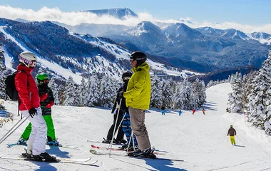 Pessoas paradas em uma pista de esqui.