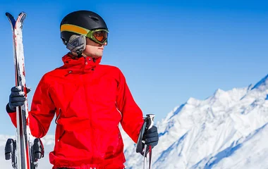 Pessoa com roupa vermelha e equipamentos de esqui.