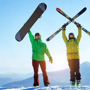 Dois homens erguendo as pranchas de snowboard para o alto.