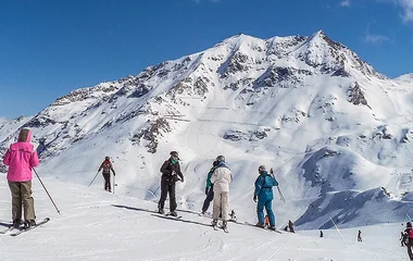 grupo de pessoas esquiando em montanha com neve