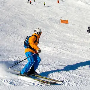 Homem esquiando com roupa amarela e azul.