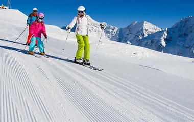 Pessoas descendo uma pista de esqui.