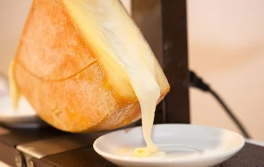 Queijo raclette com uma parte derretida.