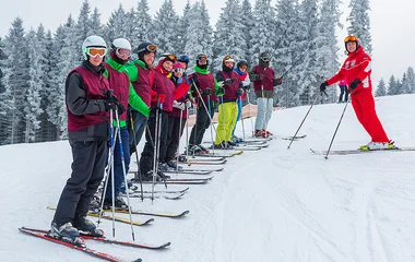 Aula de esqui para um amplo grupo de iniciantes.