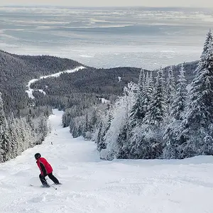 Homem esquiando em montanha no Quebec.