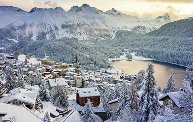 Vista aérea da cidade de St Moritz com seus chalés e a montanha nevada.