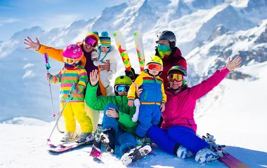 Família com roupas e equipamentos de esqui.