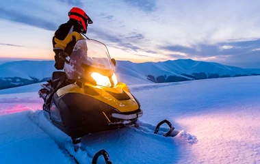 Homem na moto amarela de neve.