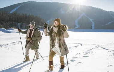 Homem e mulher praticando caminhada nórdica.