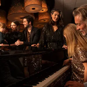 Criança e adulto tocam piano na noite festiva no restaurante