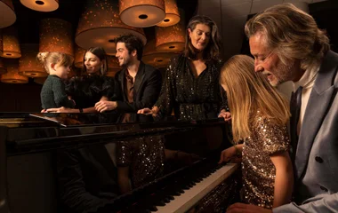 Criança e adulto tocam piano na noite festiva no restaurante