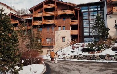 Duas mulheres caminhando lado a lado em direção ao resort Club Med nos alpes