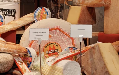 Queijos em cima de uma mesa com toalha vermelha.