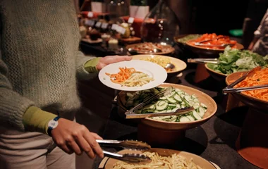 Mulher montando um prato no restaurante.
