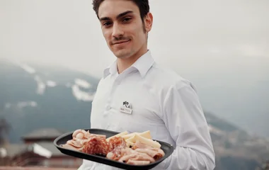 GO com um prato na mão servindo aperitivos