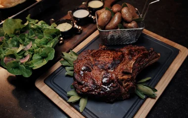 Plato de carne servido, acompañado de papas.