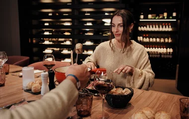 Casal comendo fondue e bebendo vinho.