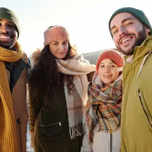 Quatro amigos com roupas de neve tirando uma foto.
