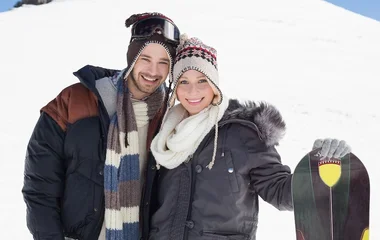 Casal com roupas de frio na neve.