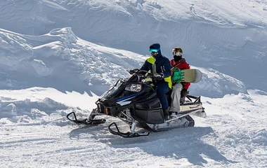 Duas pessoas na moto de neve.