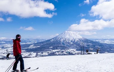 Esquiador com óculos e roupa de inverno na estação de esqui.