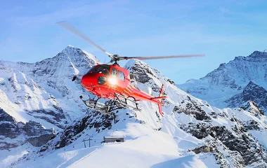 Helicóptero vermelho voando nos Alpes.