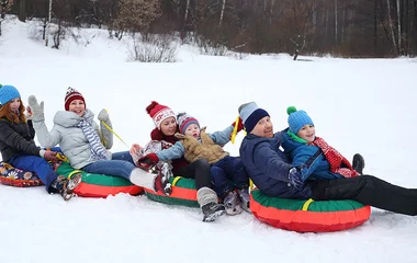 Família praticando snowtubing.