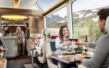 Casais tomando vinho e espumante no vagão do trem.