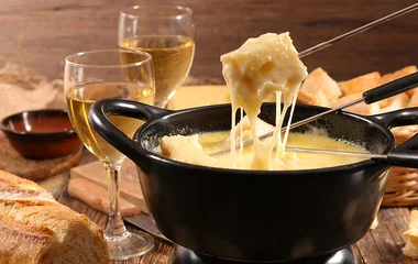 Mesa com fondue de queijo.