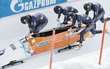Equipe de bobsled iniciando uma prova.