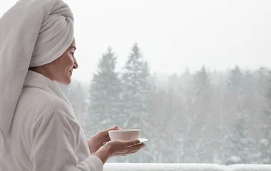 Mulher com toalha enrolada no cabelo e roupão.