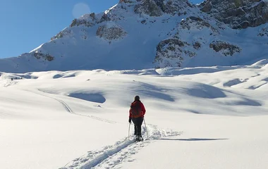 Pessoa caminhando com raquete na neve.