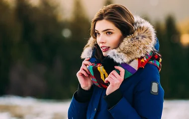Mulher com casaco azul e pelúcia na ponta da touca.