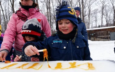 Criança fazendo pirulito de maple syrup no gelo.