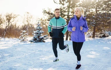 Casal correndo na neve