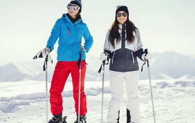 Duas mulheres usando roupas para esquiar.