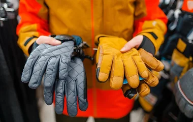 Pessoa segurando luvas de esportes de neve.