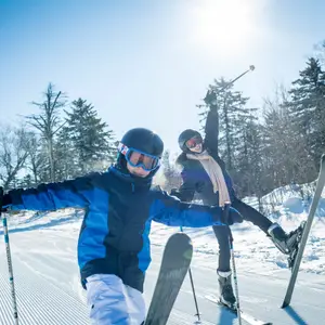 Adulto e criança andando em estação de esqui na China.