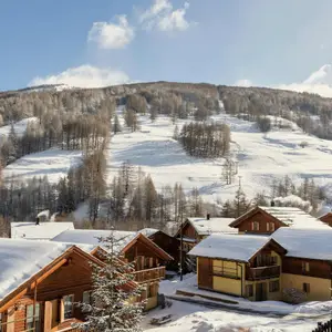 Vista aérea de las villas del Club Med Pragelatto de día con sus tejados nevados