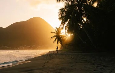 Mulher na praia, observando a paisagem.