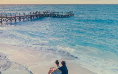 casal observando o mar sentados em uma rocha