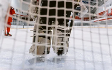 Visão de trás da rede com o goleiro posicionado.