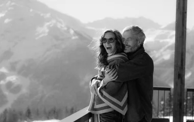 casal se abraçando com visual das montanhas cobertas de neve ao fundo