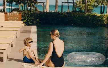 Mulher e filho na beira da piscina.