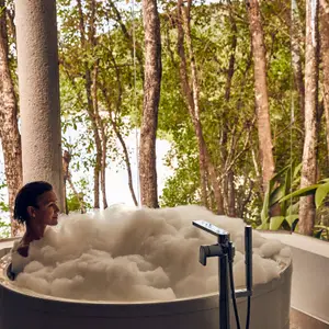 mulher em banho de banheira com espuma