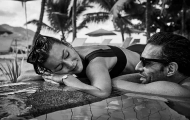Casal deitado na borda da piscina