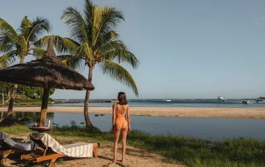 mulher de maiô em praia paradisíaca